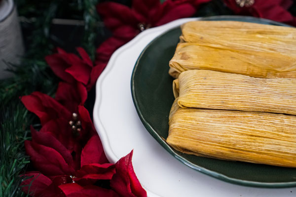 Picture this: You've received your shipment of tamales and pull them out the Christmas morning to find they are frozen! Don't forget to reheat your tamales this Christmas these four ways. Fry Up a Breakfast Tamale Try frying your tamale for a delicious breakfast!  Simply:  •	Heat your pan on your stovetop on medium heat.  •	Add a small amount of cooking oil or butter and allow it to simmer.  •	Then place the tamales on the stovetop to heat.  •	Once your tamale heats on both sides, use the pan for cooking yourself a side of eggs and salsa!  Alternatively, you can use your air fryer! Preheat your air fryer up to 375ºF, place tamales in the air fryer basket, and cook for 8 minutes!   Steam for Soft Tamales For softer tamales, you can steam your tamales:  •	Place your thawed tamales with the corn husk and steam in a stockpot. •	Steam tamales with a rice cooker or slow cooker for about 15 to 20 minutes.  •	Steam tamales in the microwave by wrapping them in a damp paper towel and heating for 3 to 5 minutes. Reheat Your Tamales Slowly Get the juicy benefits of heating your tamales slowly in an oven.   •	Preheat your oven to 350ºF. •	Avoid drying them out beforehand. •	Wrap your tamales in tin foil.  If you've defrosted your tamales, they may be ready in about 15 to 20 minutes. If frozen, give them about 25 minutes. The Best Tamales are En El Comal Many customers prefer reheating tamales using a comal, also known as a griddle.:  •	Allow your tamales to thaw out for thirty minutes. •	Set your stovetop to medium to high heat.  •	Place the tamales (with the husk) on the griddle.   Some people prefer to char the husks on all sides for a bit of crunch!  Thank You for Enjoying the Best Tamales in Texas! Thank you for making Delia's tamales in the valley a part of your holiday family tradition. Don't forget to pick up any pre-ordered tamales at your local Delia's locations in Texas.
