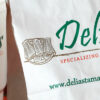 large bag and cup of delias Texas tamales