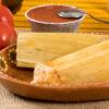 tamales delivered in Texas on a wooden platter.