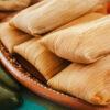 green chiles and the best tamales in Texas on a wooden platter.